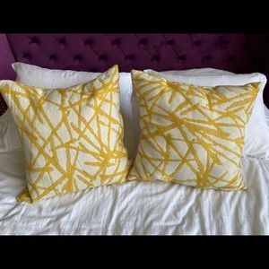 Two yellow/white throw pillows